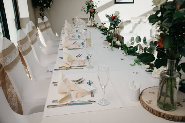 istock Rustic Wedding Reception Top Table seating with glasses, cutlery and dishes 1427241786