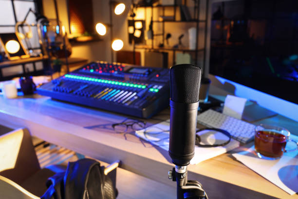 istock Microphone near table with professional mixing console in radio studio 1427246098
