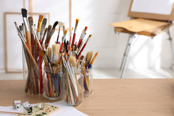 istock Different brushes, paints and palette on wooden table indoors, space for text. Artist's workplace 1427246249
