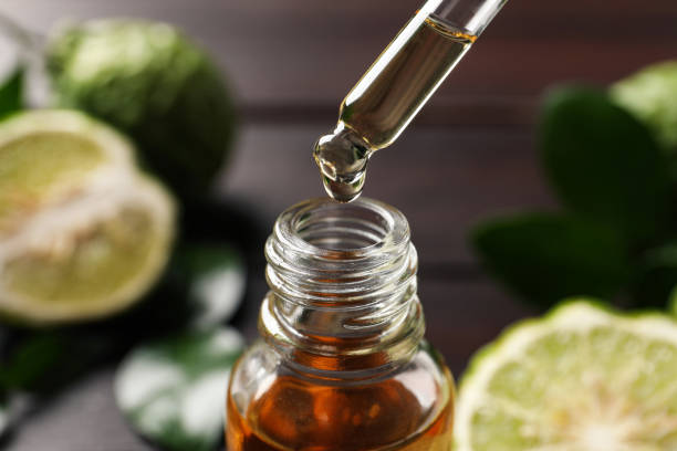 istock Bergamot essential oil dripping from pipette into bottle on blurred background, closeup 1427246442