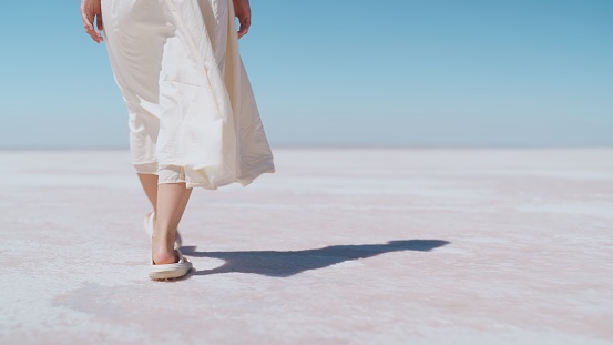 A Young female tourist is walking on white salt in Salt Lake Türkiye.