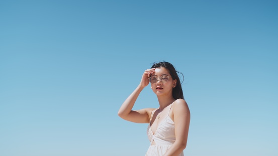 A portrait of a beautiful Japanese woman against clear blue sky.