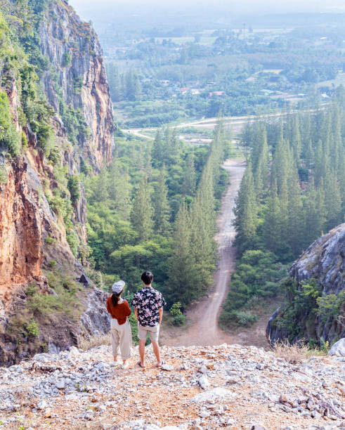istock young couple top on mountain look forward 1427255186