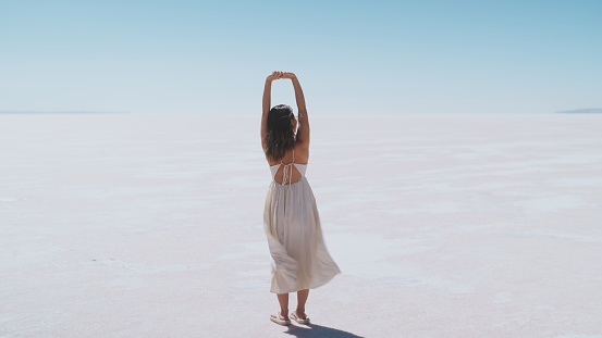 A young female tourist is standing on white salt in Salt Lake Türkiye.