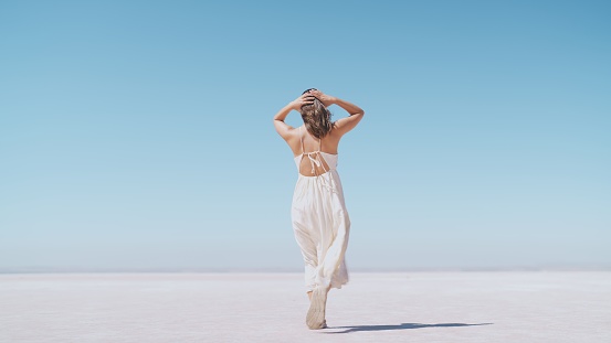 A young female tourist is walking on white salt in Salt Lake Türkiye.