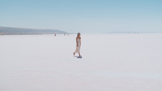 A young female tourist is walking on white salt in Salt Lake Türkiye.