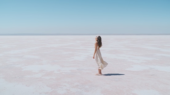 A young female tourist is standing on white salt in Salt Lake Türkiye.