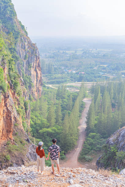 istock young couple top on mountain look forward 1427256120