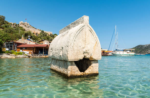 Semi-submerged Lycian sarcophagus tomb by the shore of Kalekoy village of the Demre district in the Antalya Province of Turkey. Kalekoy, Antalya, Turkey - August 14, 2021. Semi-submerged Lycian sarcophagus tomb by the shore of Kalekoy village of the Demre district in the Antalya Province of Turkey. kekova stock pictures, royalty-free photos & images