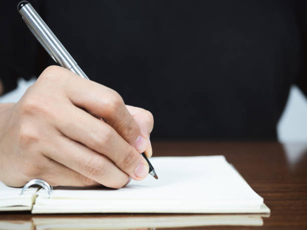 istock Close up man hand writing pen on diary page on table 1427258888