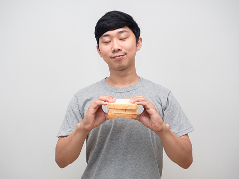 Healthy young man close eyes holding sandwich in hand portrait