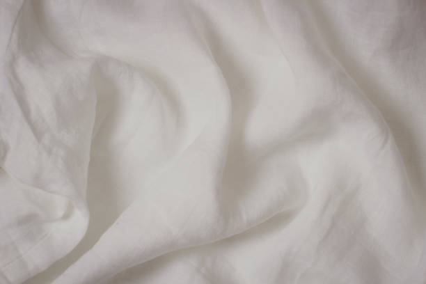 istock White crumpled linen fabric texture background. Natural linen canvas organic eco textiles background. Top view 1427269638