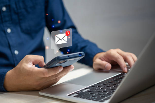 istock businessman holding hand touchscreen smartphone and checking email icon online or sending mail to partner and customer on web with virtual interface technology concept. 1427270213