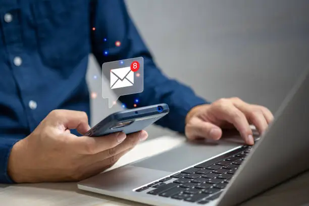 Photo of businessman holding hand touchscreen smartphone and checking email icon online or sending mail to partner and customer on web with virtual interface technology concept.