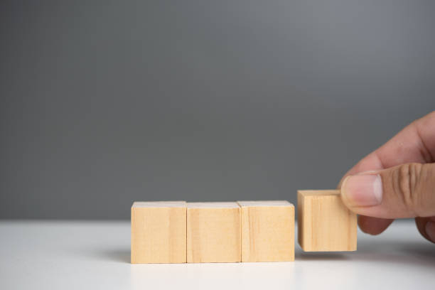 istock hand holding cube wood block blank on background. copy space 1427270303