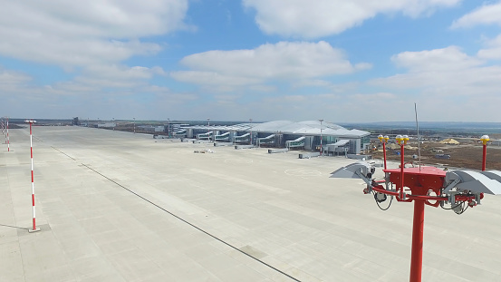 Aerial view of the modern international airport terminal. Traveling around the world. Empty airport aerial. View of runway at the airport. Airfield marking on taxiway is heading to runway 4K