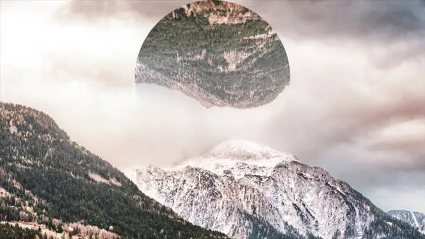 Photo of Abstract mountains covered with green forest and snow, big circle with the landscape reflection upside down. Mountainous landscape and a circle with mountains reflection, nature and geometry concept.