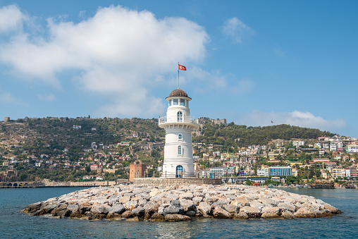 Alanya, Turkey - August 19, 2021. Alanya Deniz Feneri lighthouse in Alanya, Turkey. View with the Turkish flag on top.