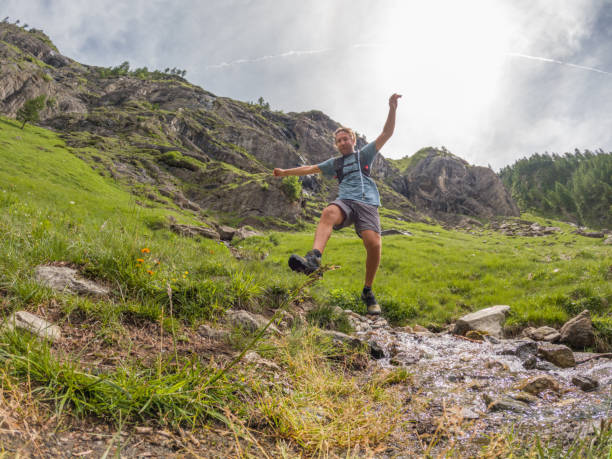 istock Man trail runner jumping water stream 1427276462