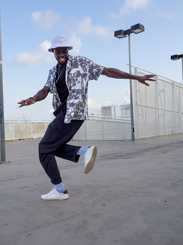 African American man dancing in the street on a sunny day.