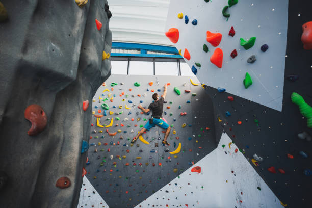 Athletic man climbing indoor wall. stock photo