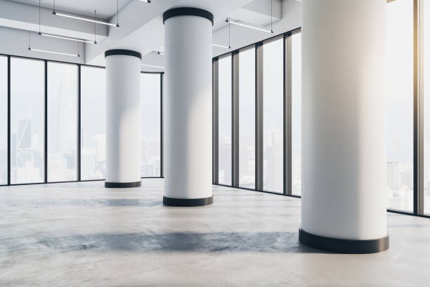 istock Real estate concept with perspective view on huge white columns on concrete floor in spacious empty hall with city view from glass walls separated by black frames. 3D rendering 1427280519