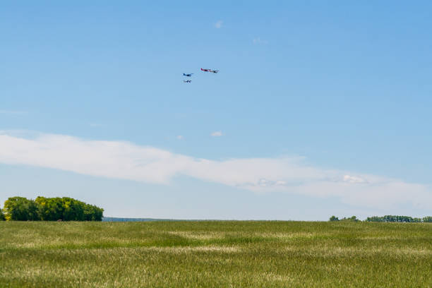 istock Four light aircraft are flying over an agricultural field. 1427289364
