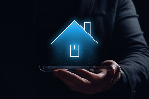 Hologram of the house over the smartphone in the hands of the person. stock photo