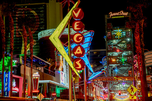 Las Vegas, USA - March 9, 2019: view to cowboy Vic in the Fremont street by night, illuminated by light bulbs  and entrance of Fremont street experience in Las Vegas, USA.
