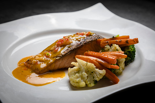 Dish of salmon with vegetables with oil cooked in a restaurant in an artisanal style
