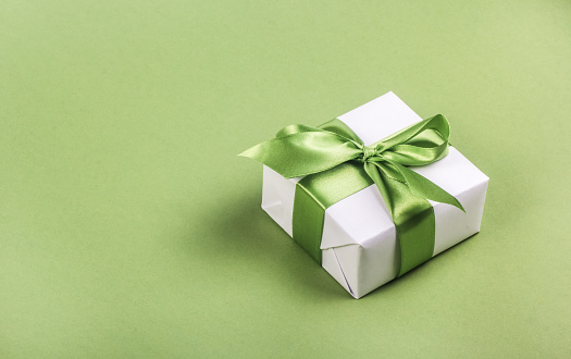 Pink gift box with ribbon on white background