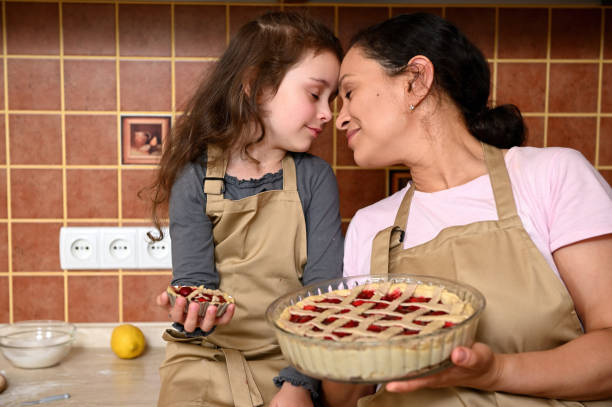 красотка, любящая мама и ее милая маленькая дочь представляют свой домашний печеный вишневый пирог с камеры - cooking thanksgiving women baking стоковые фото и изображения