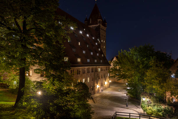 秋の夜に照らされたニュルンベルク城近くの歴史的建造物 - castle nuremberg fort skyline �ストックフォトと画像