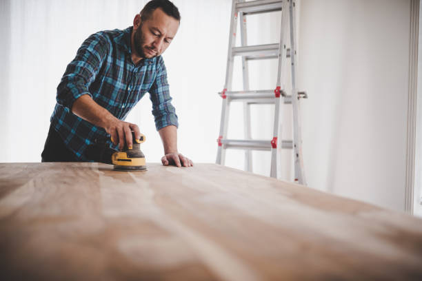 istock DYI man sanding a wood table inside his house 1427315945