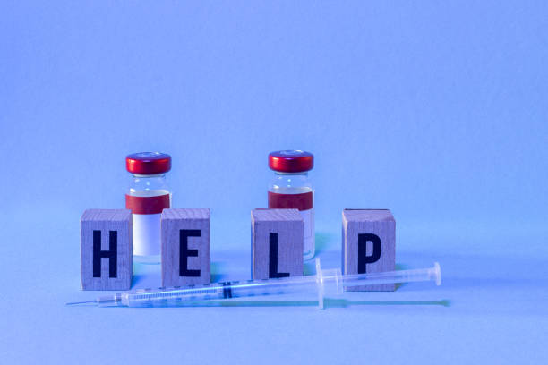 istock two doses of vaccine one syringe and HELP letters with copy space 1427317738
