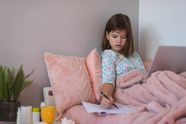 istock School girl having a flue at home, using laptop and taking notes 1427326438