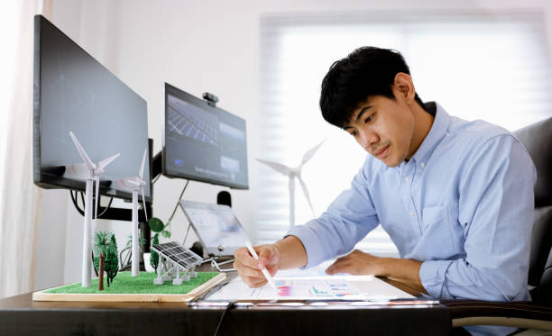 istock Young smart design engineer design Green energy system , freelance engineer work at home office ,  engineer working on the wind turbines project 1427332574