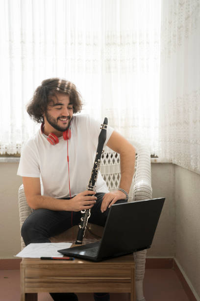 istock young man learning to play musical instrument at home online training work. 1427339530