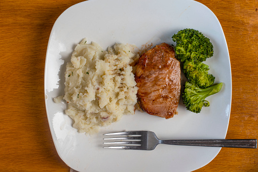 boneless barbecue pork chop served with broccoli and red mash potatoes