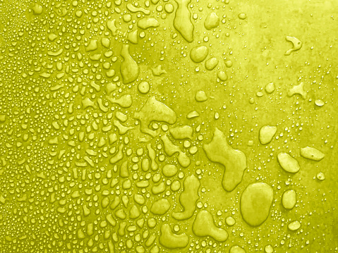 gotas de agua de diferentes tamaños en una superficie de yel, textura de gotas, lluvia en baldosas de cal, textura de lluvia, fondo refrescante amarillo, textura húmeda amarillenta photo