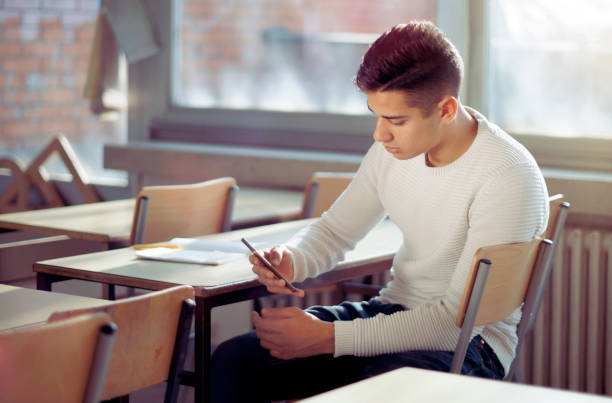 Teen phone addiction Teen phone addiction high school student classroom education student stock pictures, royalty-free photos & images