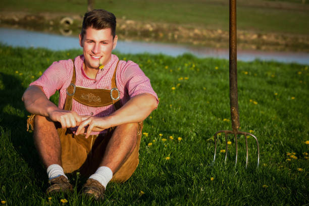 istock young blond bavarian man sitting in the grass 1427351857