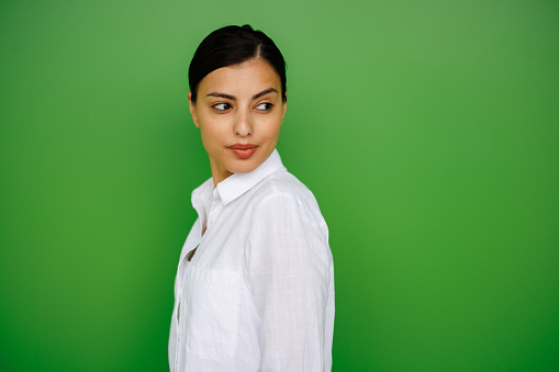 Portrait of beautiful young woman isolated on green color background