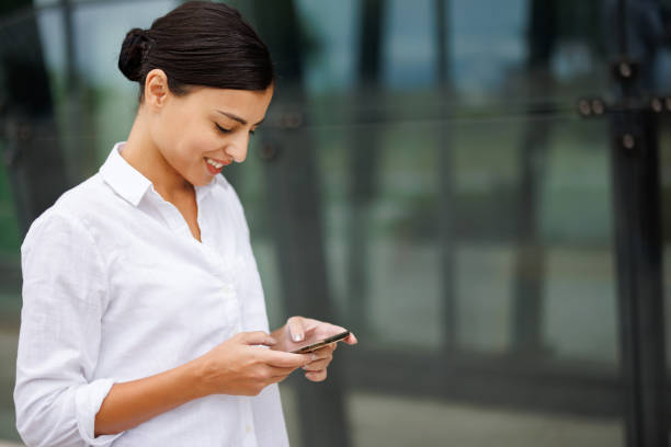 Young woman using her phone while walking in the city