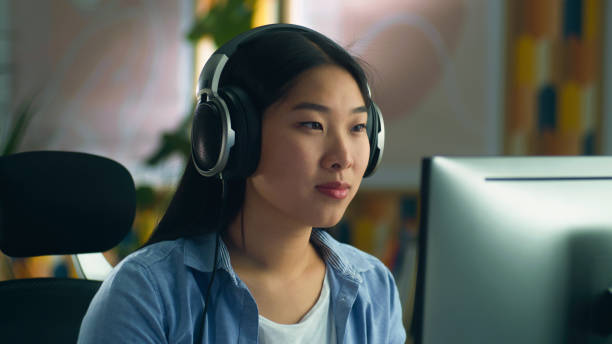istock Asian woman in headset working on pc 1427366253
