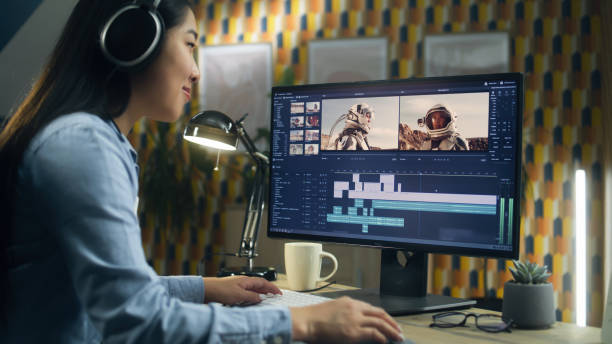 Female editor making video with astronauts Asian woman in headset editing video with astronauts for client in program on personal computer while working at the table from home office. Freelance editing equipment stock pictures, royalty-free photos & images