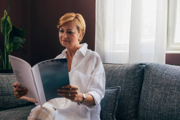 A Happy Beautiful Senior Woman Holding  Some Magazine While Rela