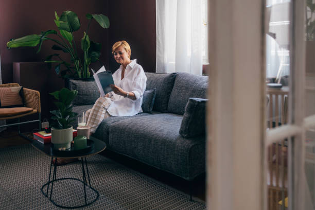 istock A Happy Beautiful Senior Woman Holding  Some Magazine While Rela 1427370017