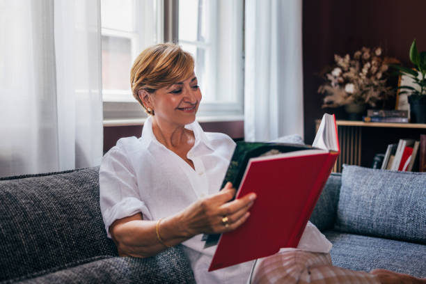 istock A Happy Beautiful Senior Woman Holding  Some Book While Relaxing 1427370041