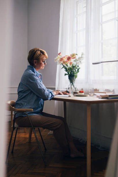 istock A Serious Beautiful Senior Woman With Glasses Writing Her Diary 1427370064